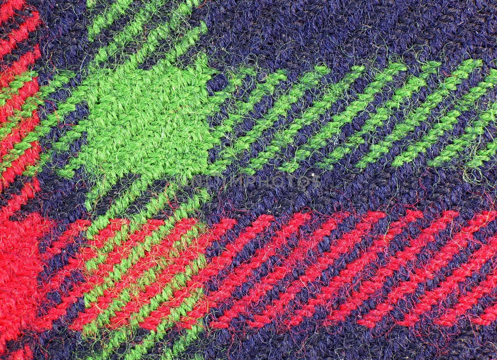 A macro view of a piece of blue cloth with green and red stripes
