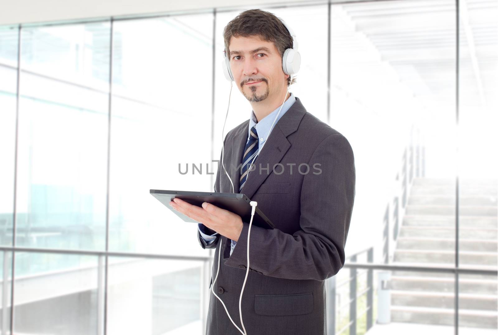 businessman with tablet pc and headphones, at the office