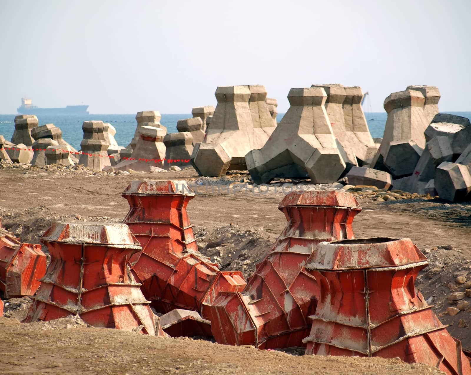 Large concrete tetrapods are placed on the sea shore

