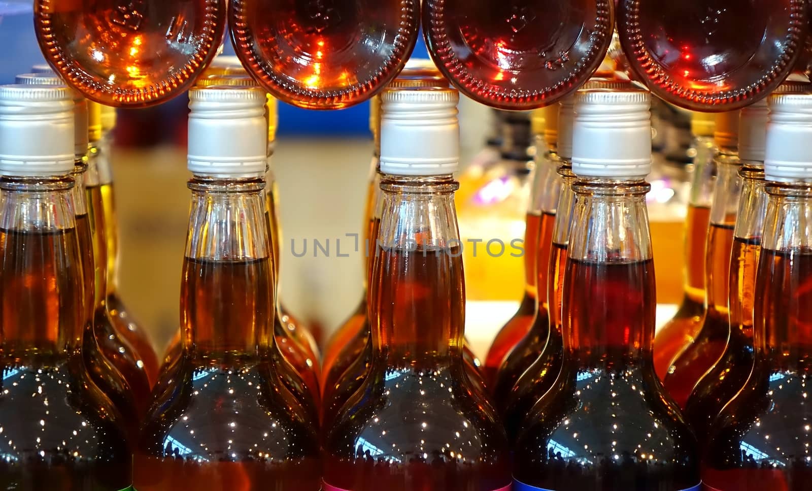Rows and stacks of glass bottles filled with vinegar
