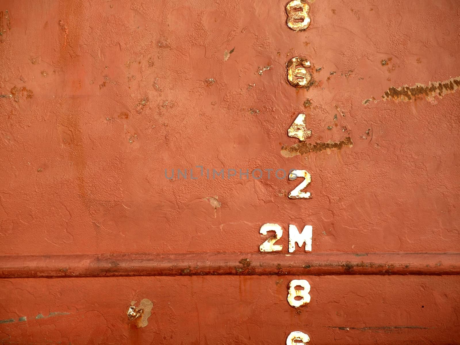 Closeup view of the waterline of a freighter ship anchored in port
