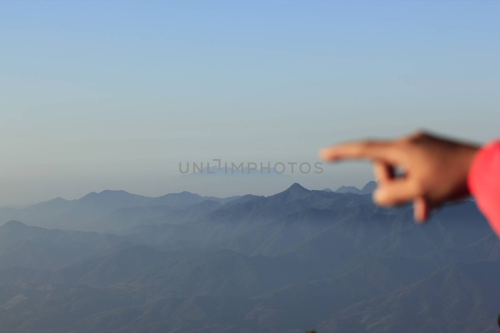 Finger pointing to the mountain.in nature