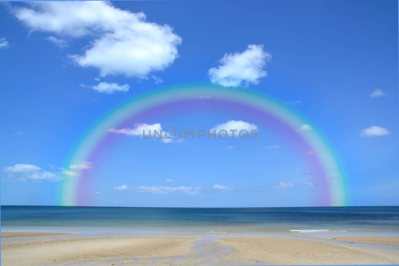 Colorful rainbow over a Tropical beach of Andaman Sea Thailand