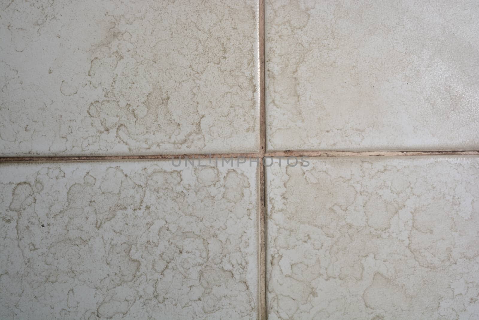 Close up of bathroom floor tile texture with water stain spot.