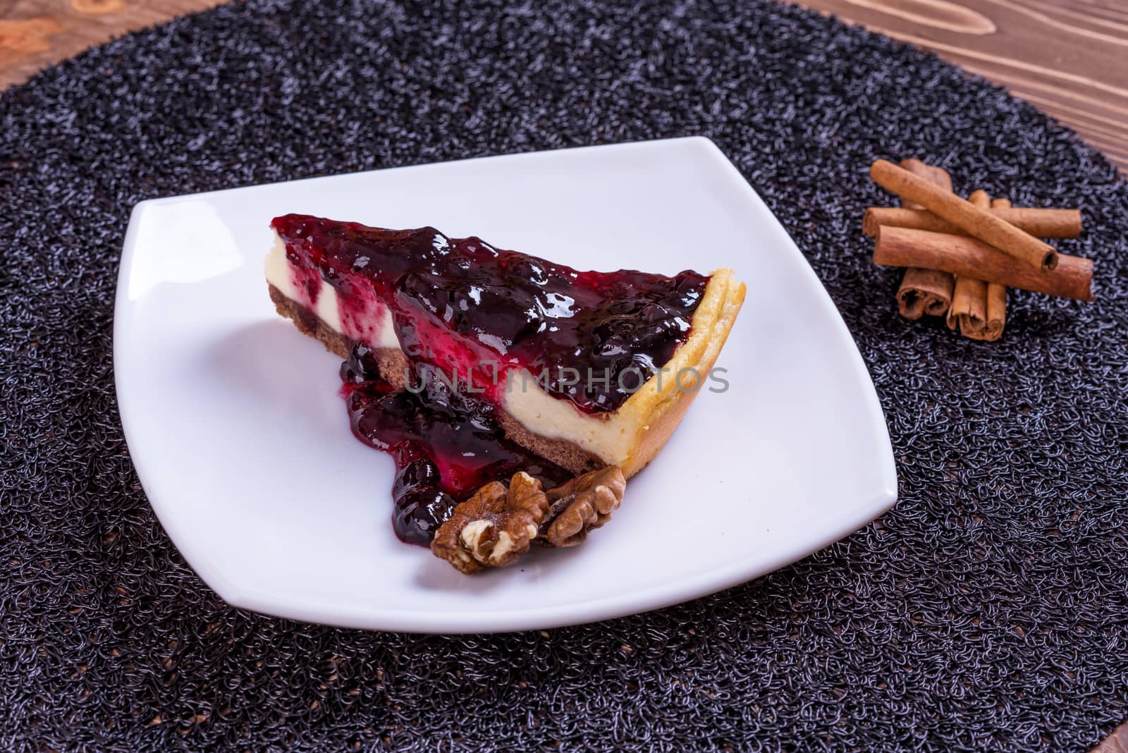 Piece of blueberry cheesecake on a plate with a silver fork.