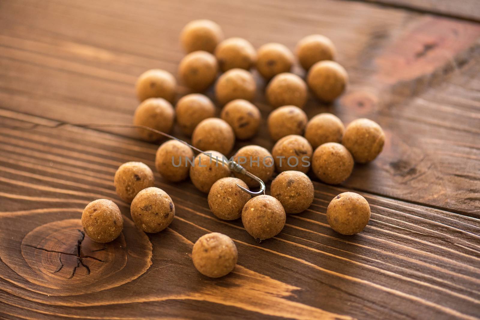 Carp fishing. Different of carp boilies and accessories for carp fishing isolated on wooden background.