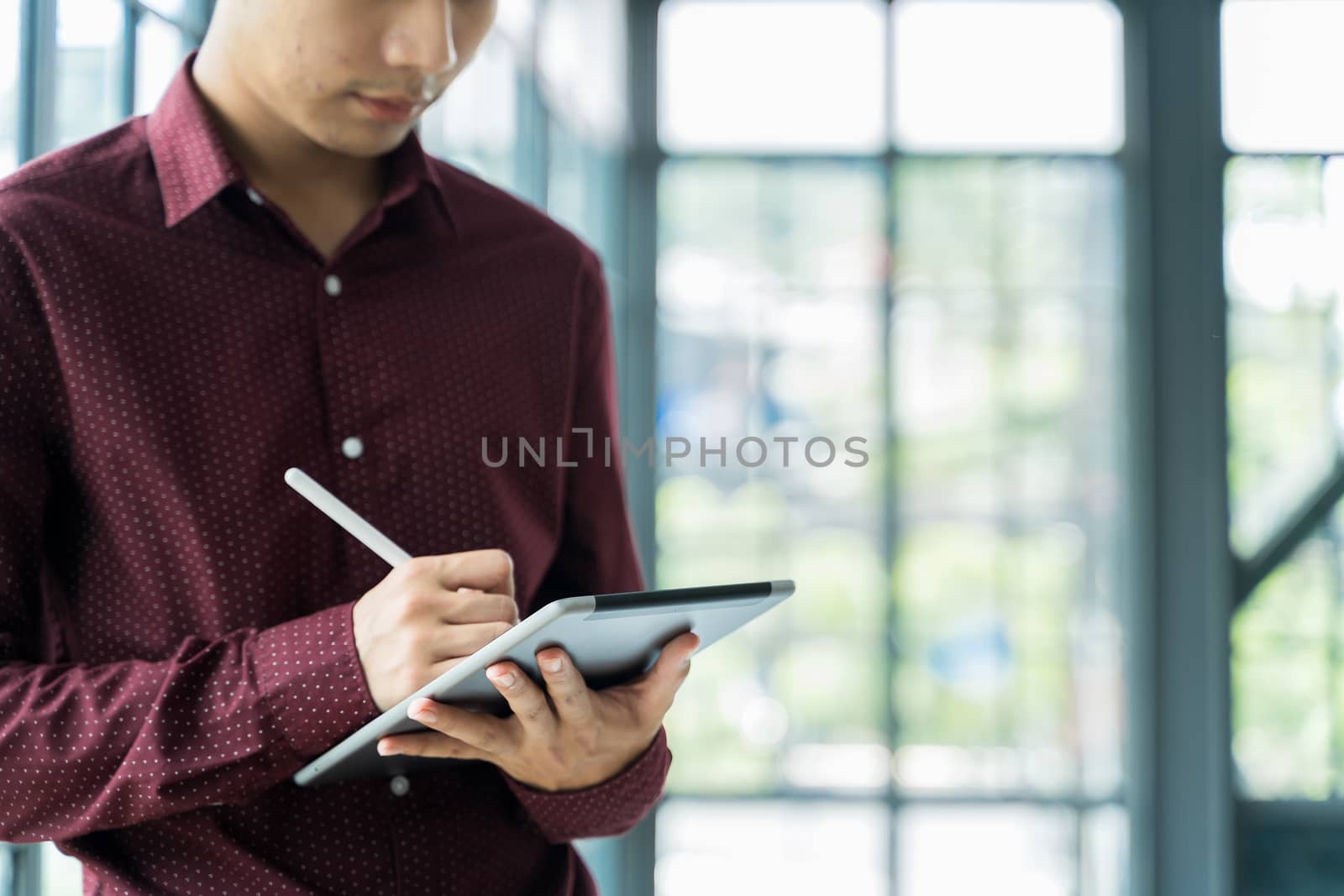 Close up Men are Using the tablet and holding it on hand. He use tablet to work, check emails, teleconferences, or social networks. During work from home at the Home Office