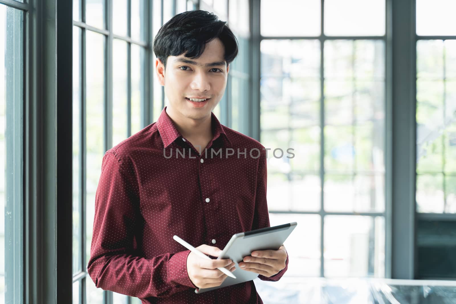 Men are smiling and cheerful. Using the tablet and holding it on by Boophuket