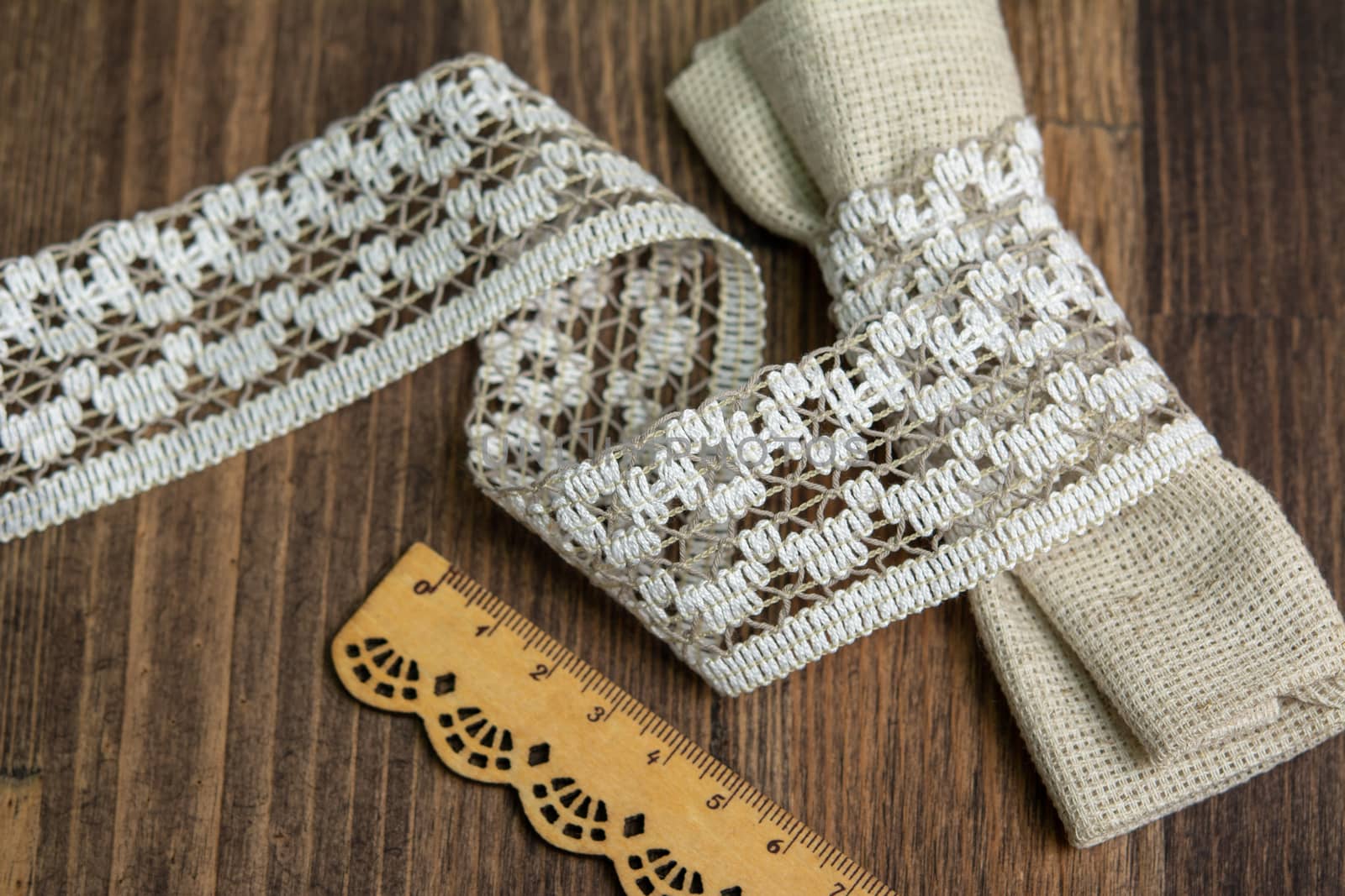 knitted beige openwork linen ribbon tapes in rural style of rustics cotton eco natural on wood ground