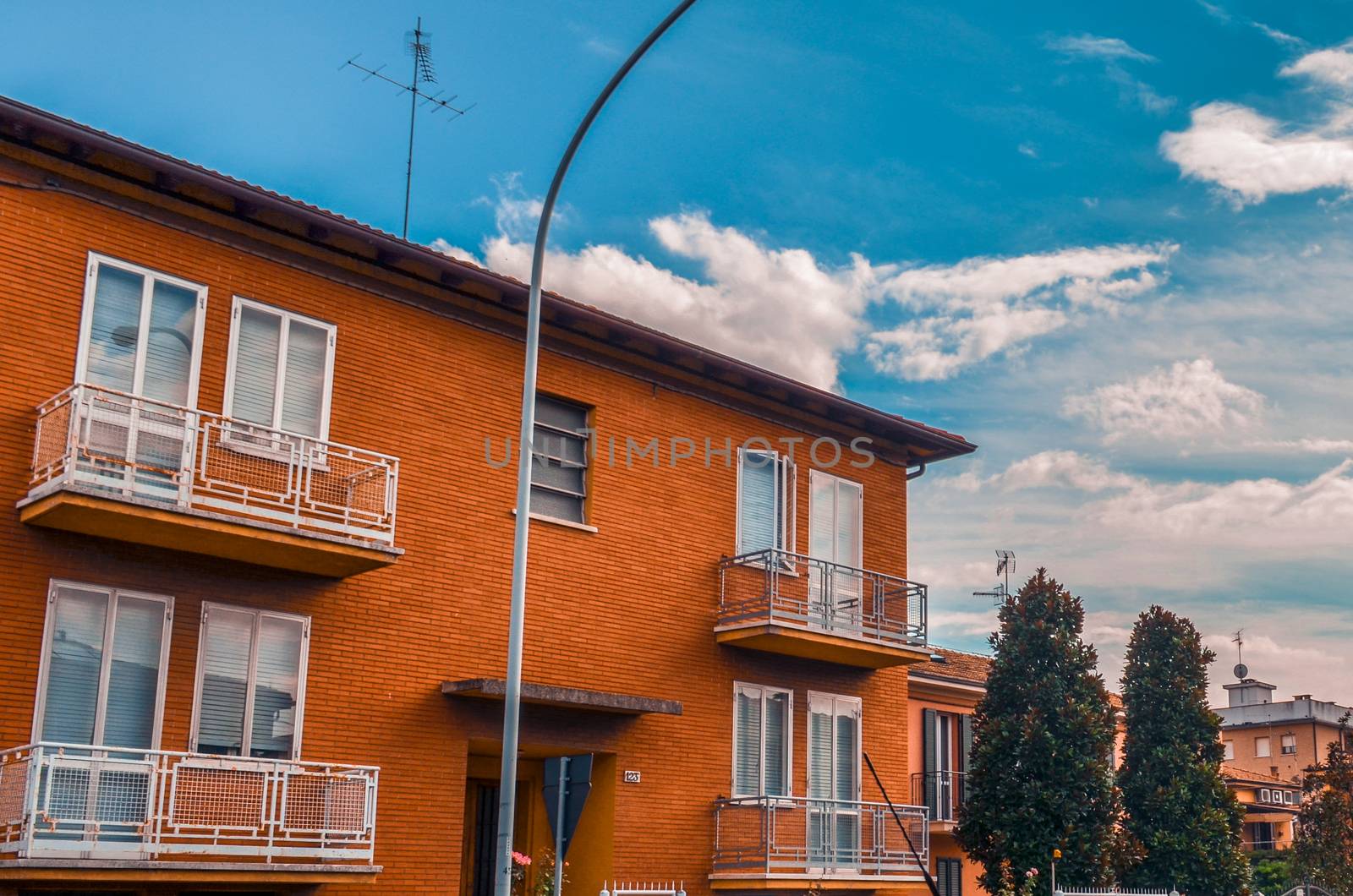 Beautiful two-storey red brick house against a blue sky in Bologna, Italy