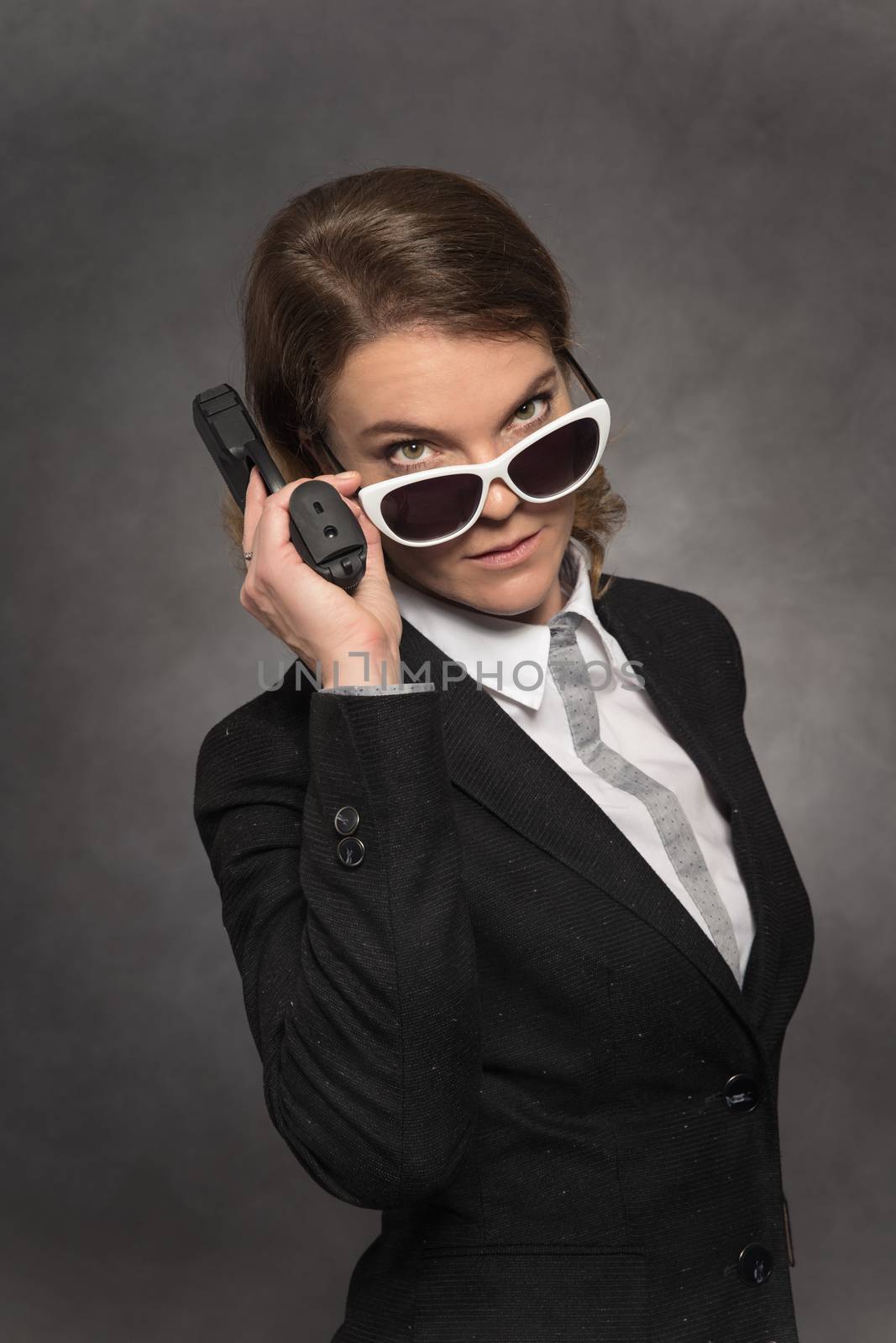 Portrait of woman with gun on black background by Edophoto