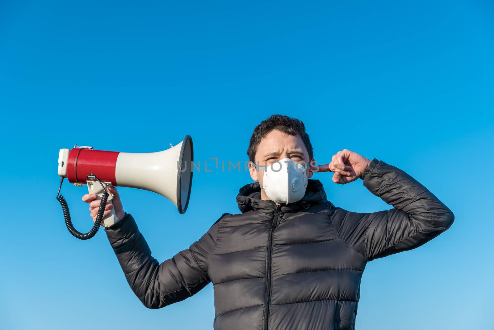 A megaphone as a symbol of spreading a huge amount of coronavirus information. Respirator protection and information filtering.