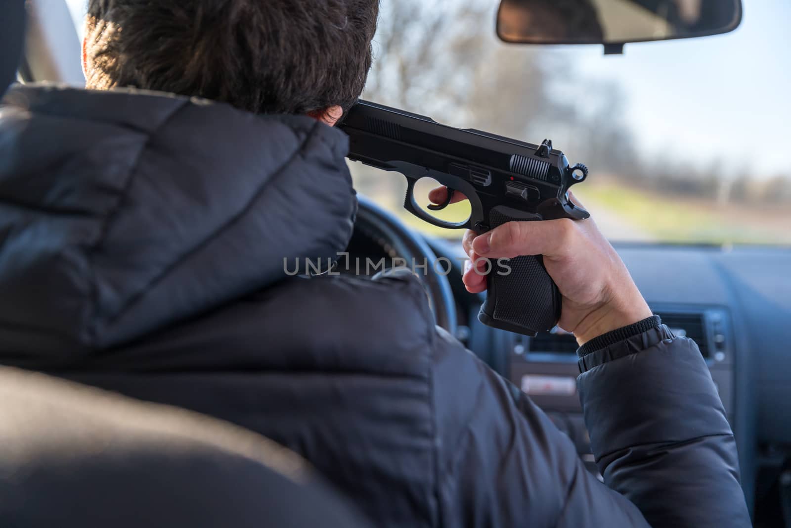 a man aiming a gun at his own head playing Russian roulette or killing himself.