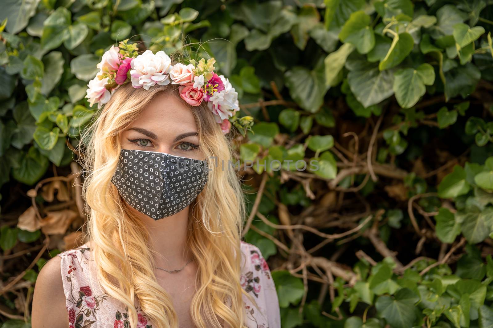 wedding portrait of a woman in a dress with a floral wreath on her head and a mask on her mouth. measures at the time of the coronavirus epidemic.