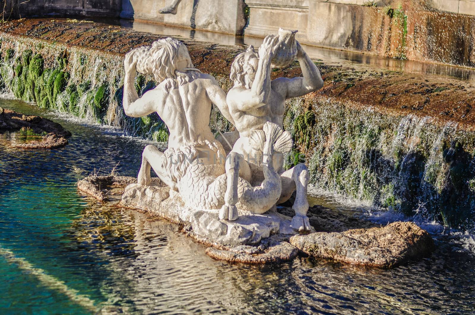 a beautiful fountain with statues and rocks