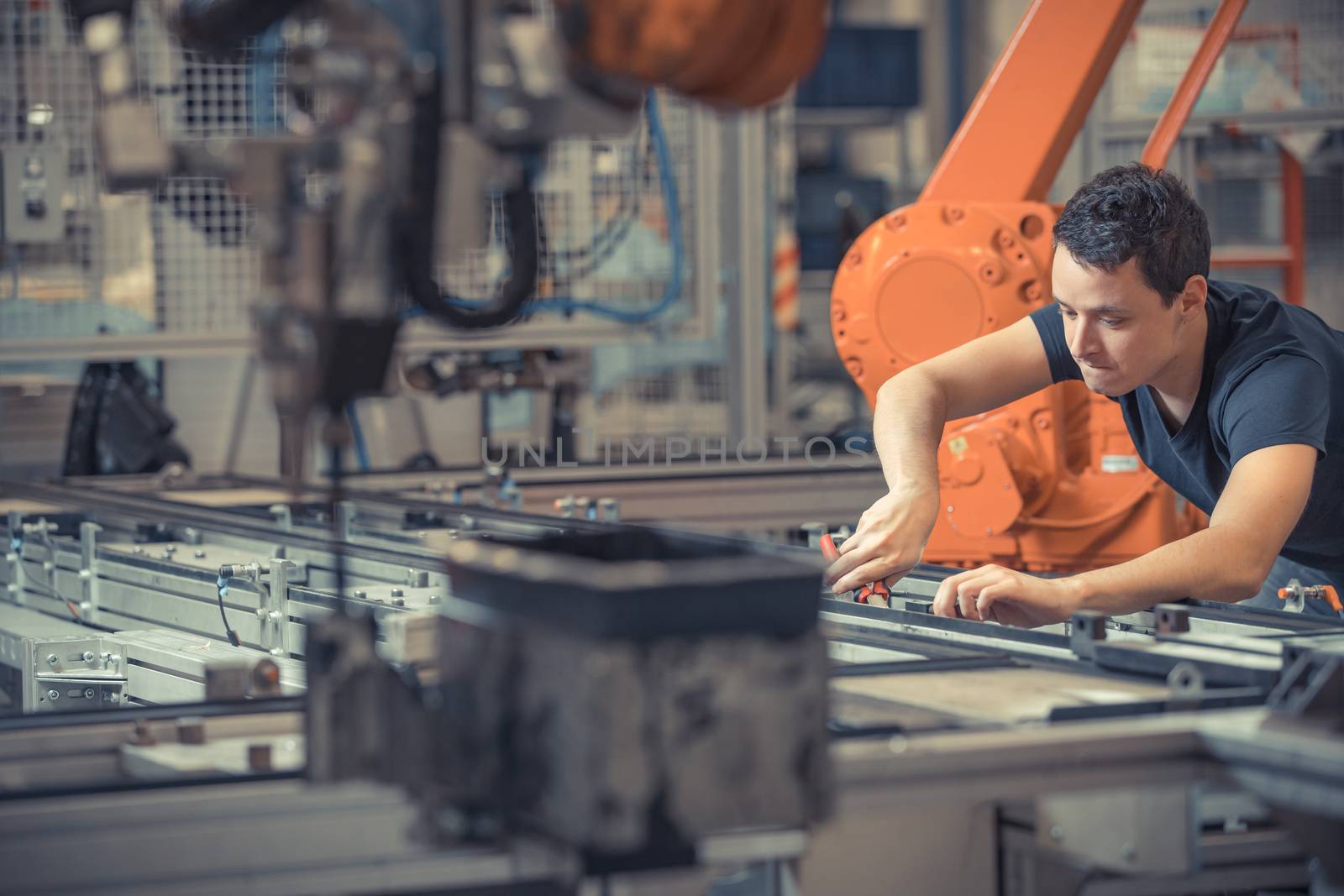 engineer performs maintenance of industrial robot in a factory.