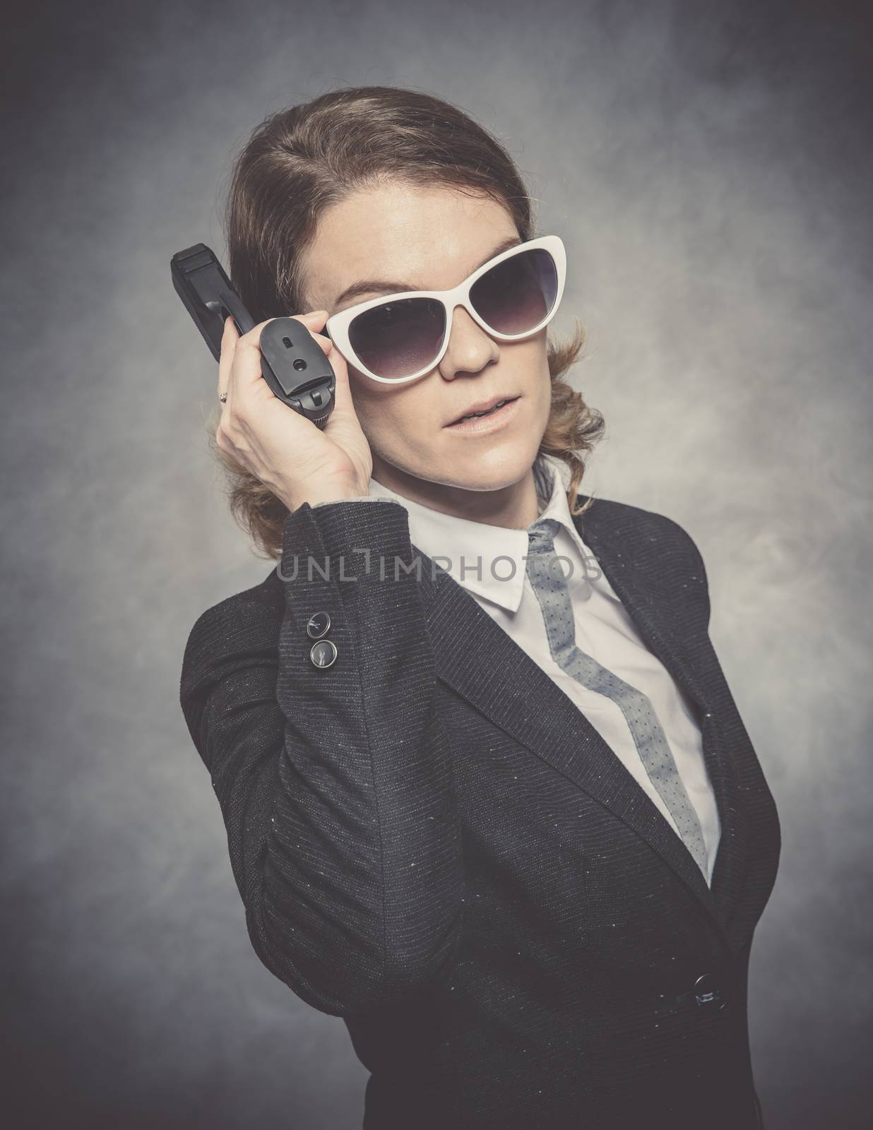 Portrait of woman with gun on black background.