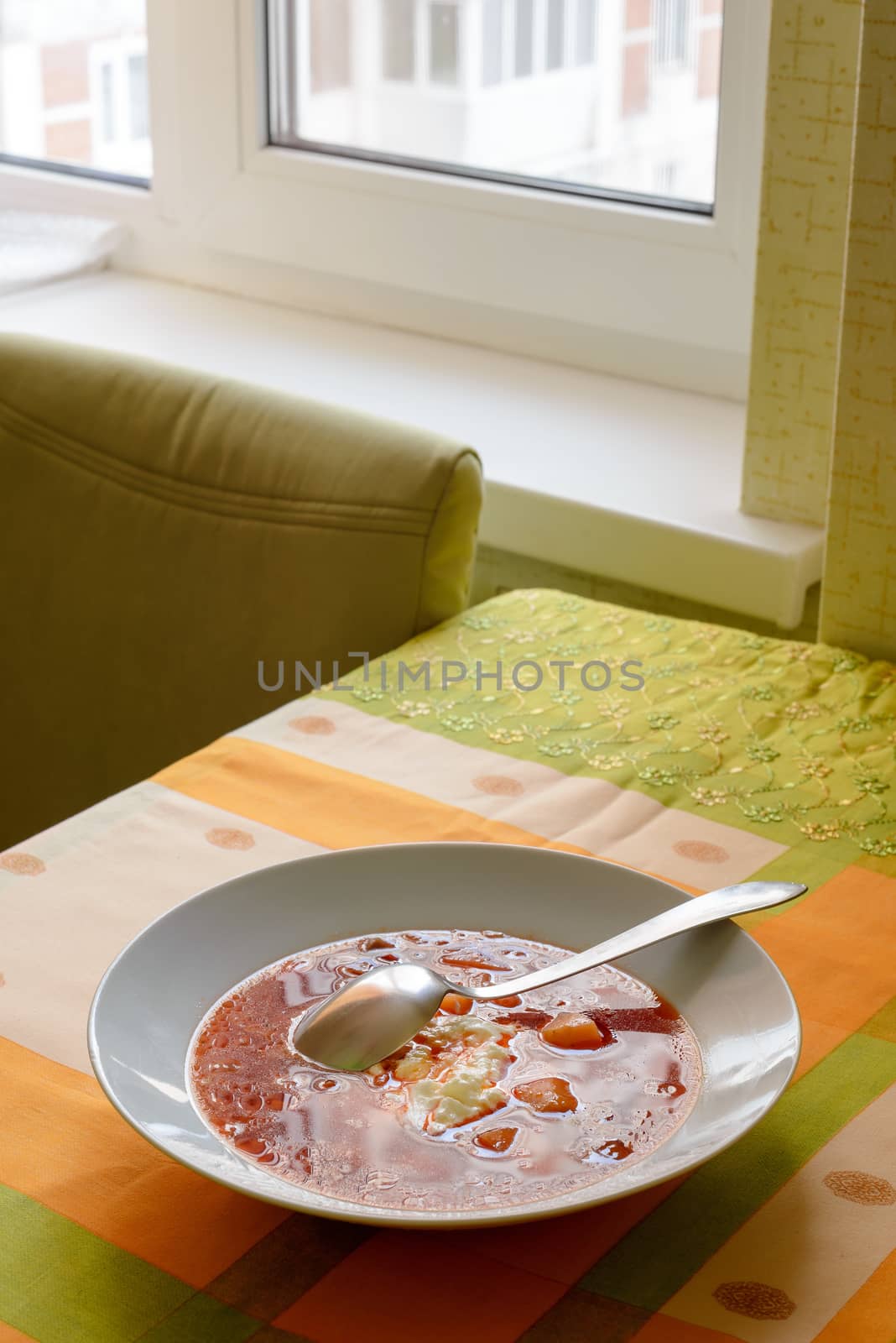 Simple traditional homemade red Ukrainian Borscht with smetana cream in a white porcelain plate