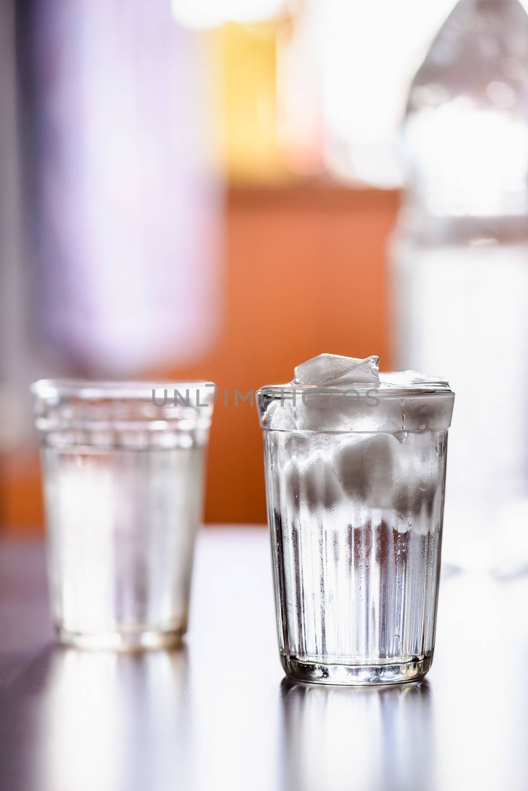 Glasses of fresh water with ice on a table