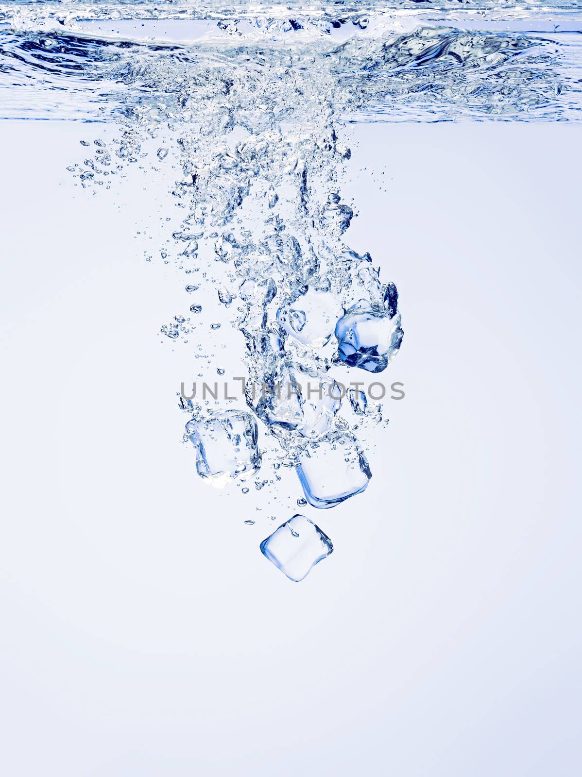 Ice cubes falling in clear water, with bubbles