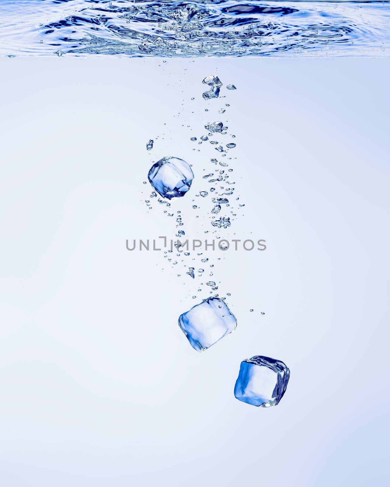 Ice cubes falling in clear water, with bubbles