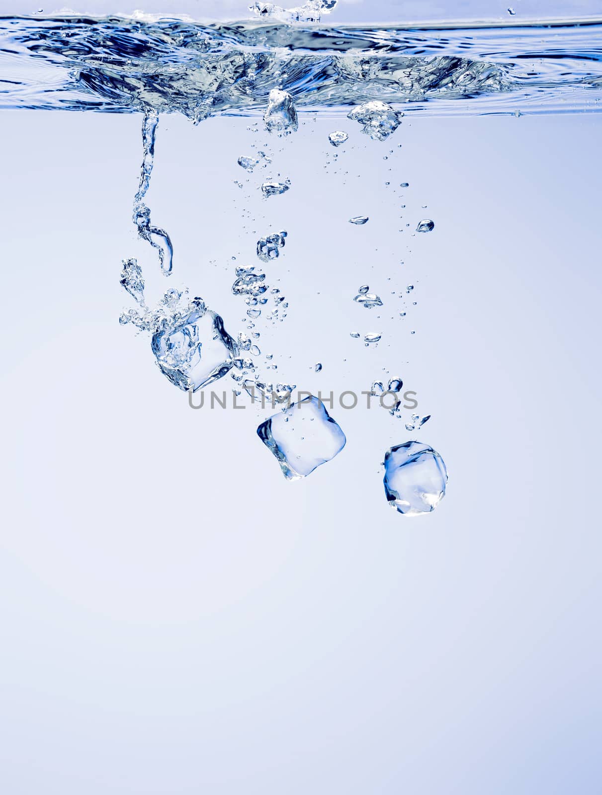 Ice cubes falling in clear water, with bubbles