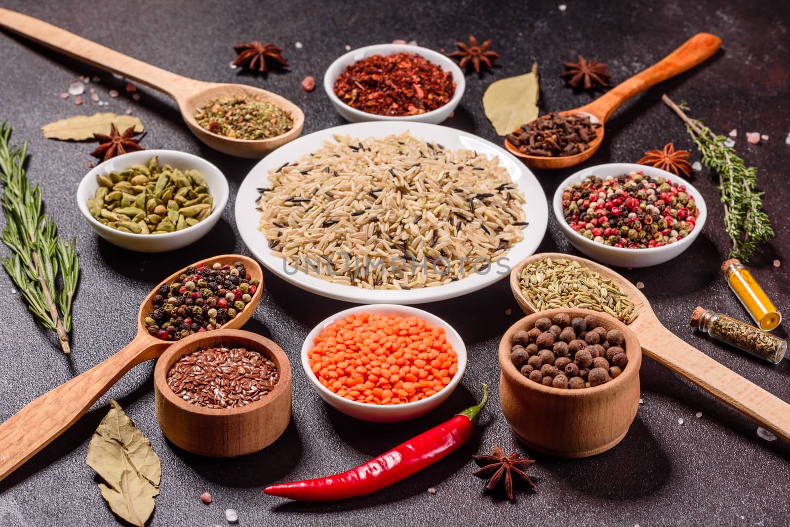 A set of spices and herbs. Indian cuisine. Pepper, salt, paprika, basil and other on a dark background. Top view. Free copy space.