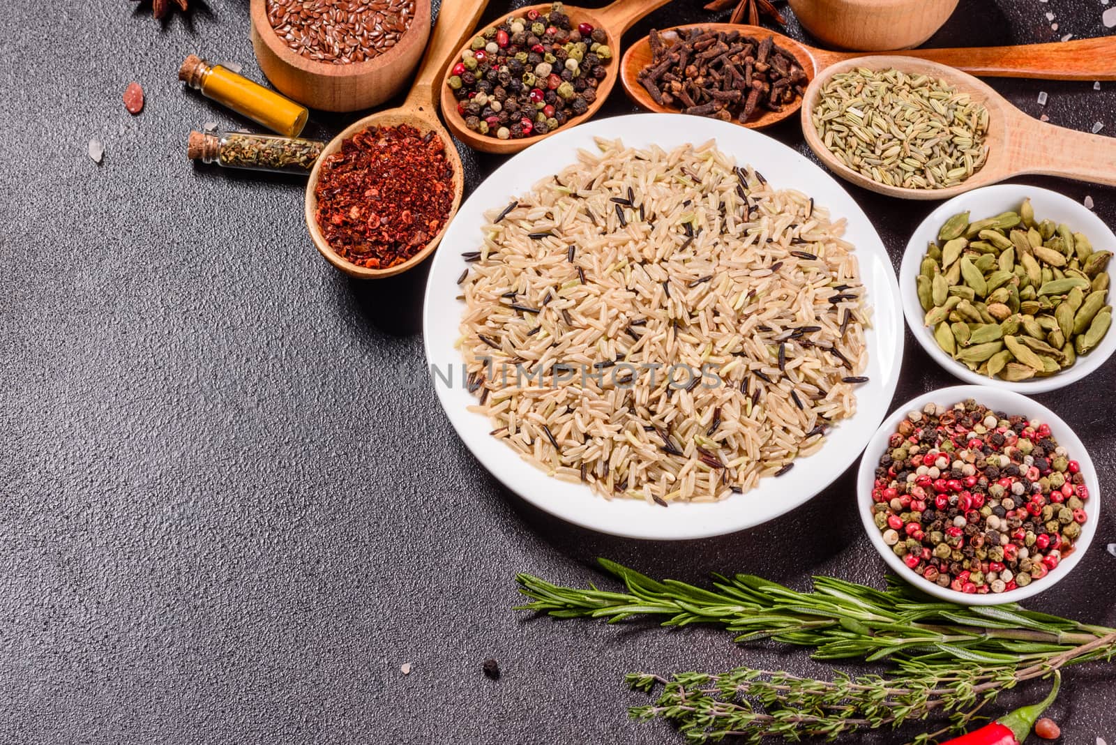 A set of spices and herbs. Indian cuisine. Pepper, salt, paprika, basil and other on a dark background. Top view. Free copy space.