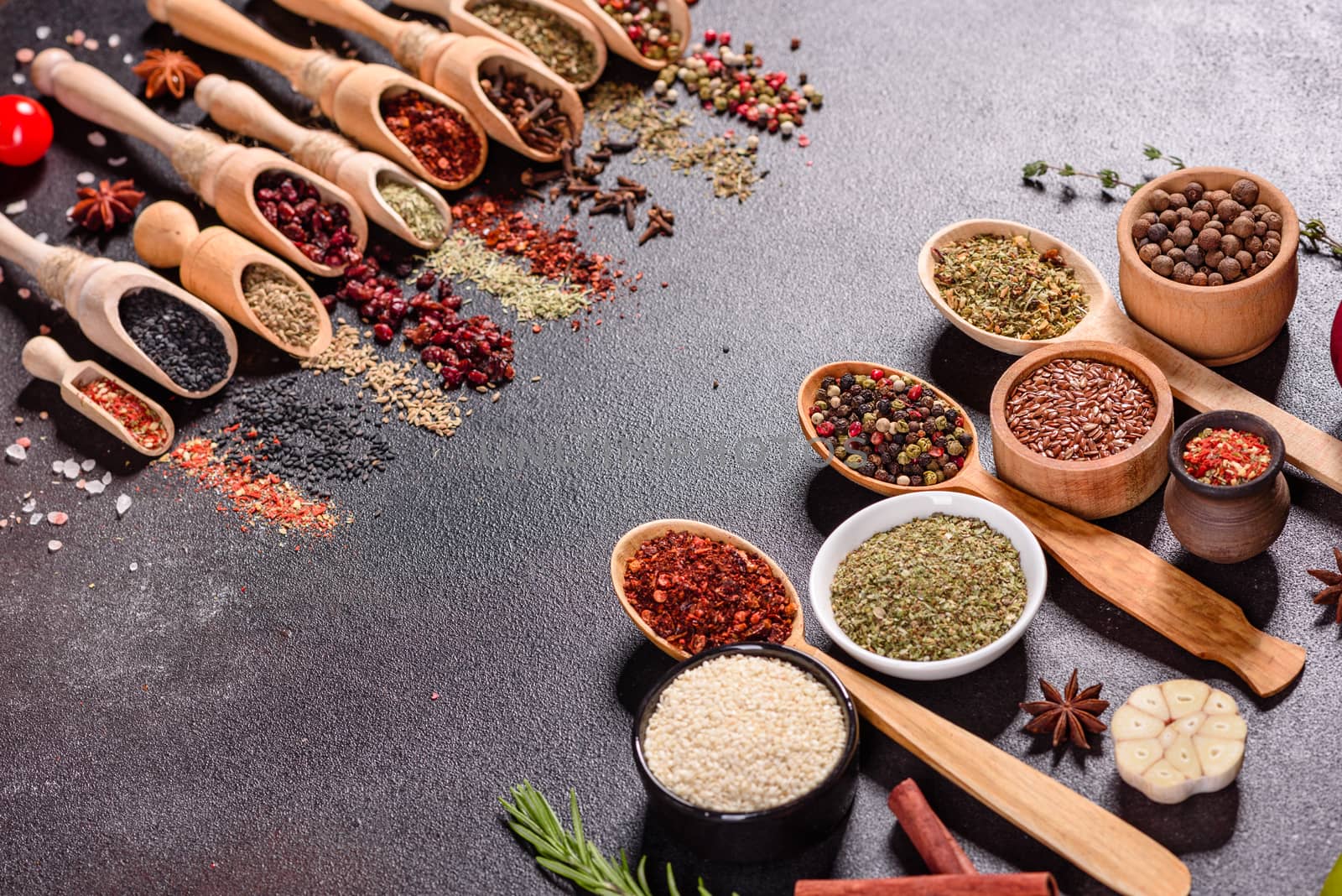 A set of spices and herbs. Indian cuisine. Pepper, salt, paprika, basil and other on a dark background. Top view. Free copy space