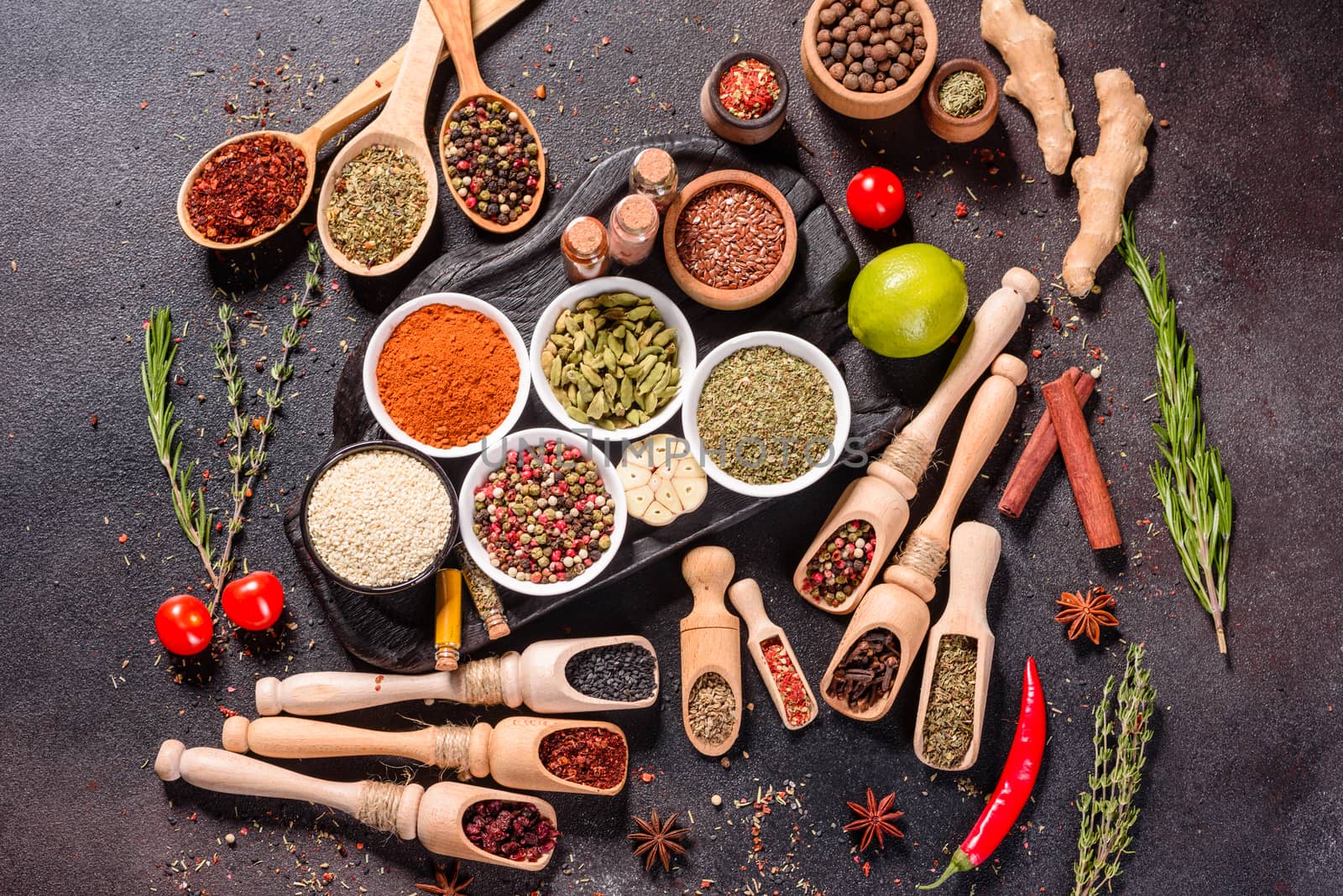 A set of spices and herbs. Indian cuisine. Pepper, salt, paprika, basil and other on a dark background. Top view. Free copy space
