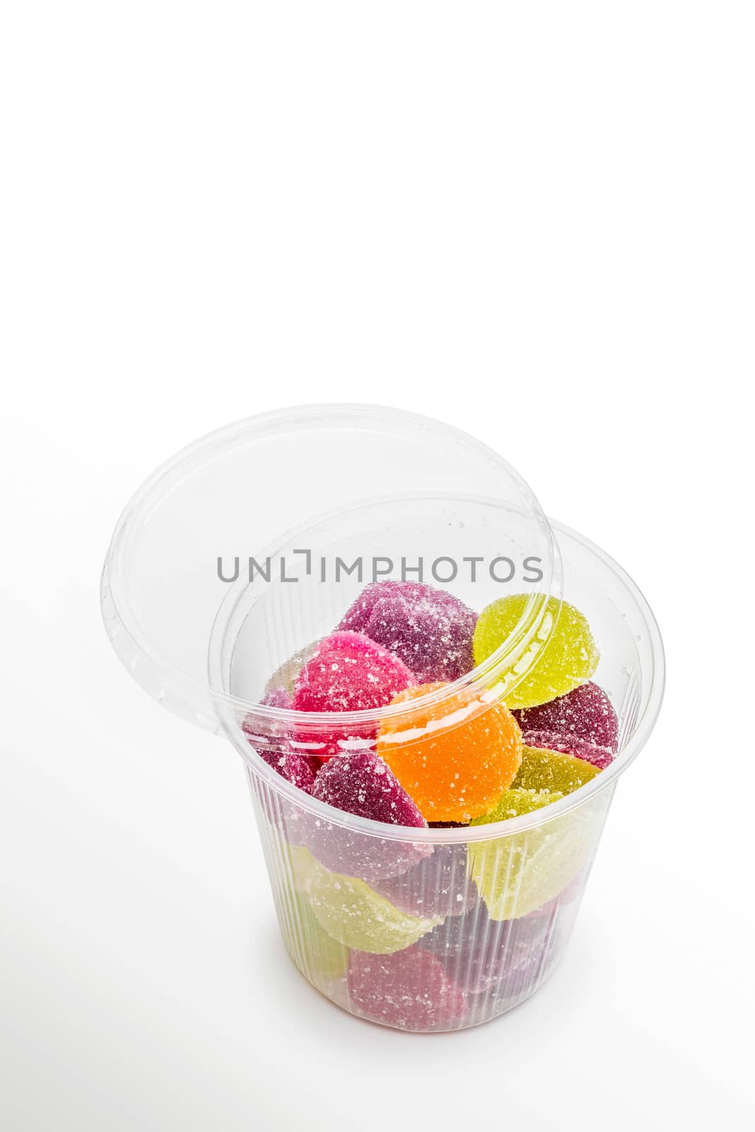 Colorful fruit jelly in open foam jar, on white background