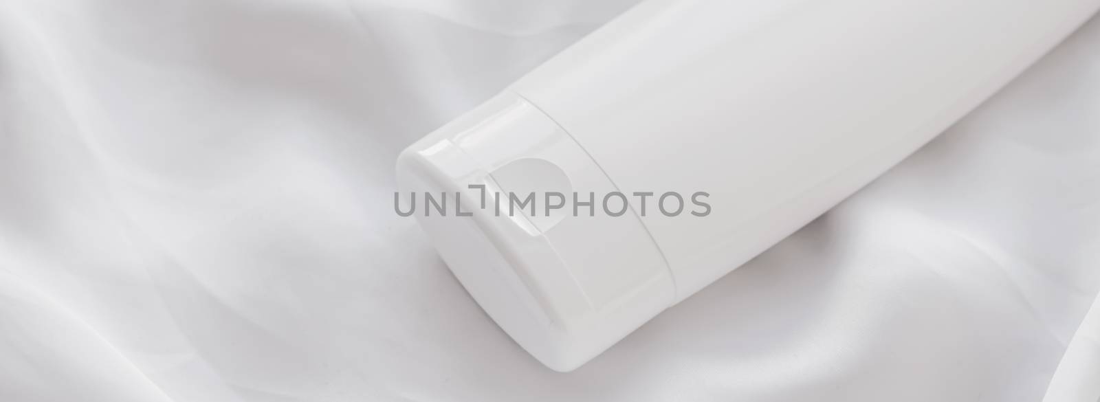 Blank label cosmetic container bottle as product mockup on white silk background, hygiene and healthcare