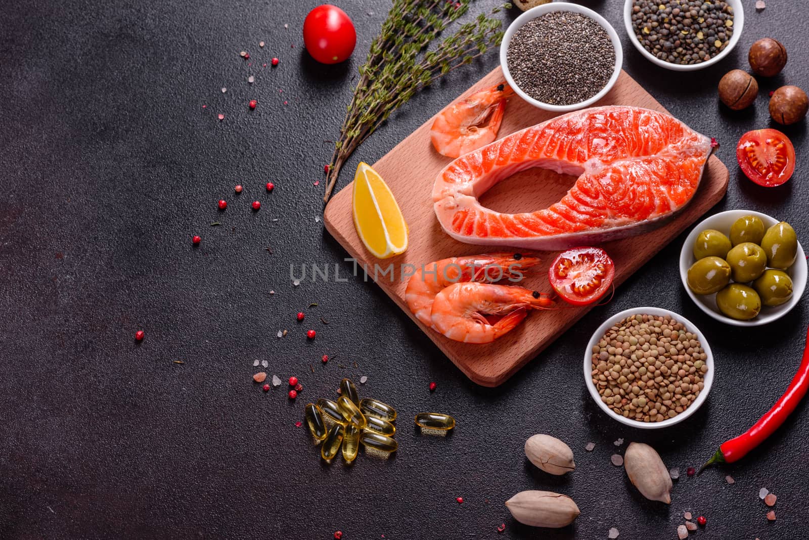 Raw trout red fish steak served with herbs and lemon and olive oil on a dark background. Cooking Salmon, sea food. Healthy eating concept