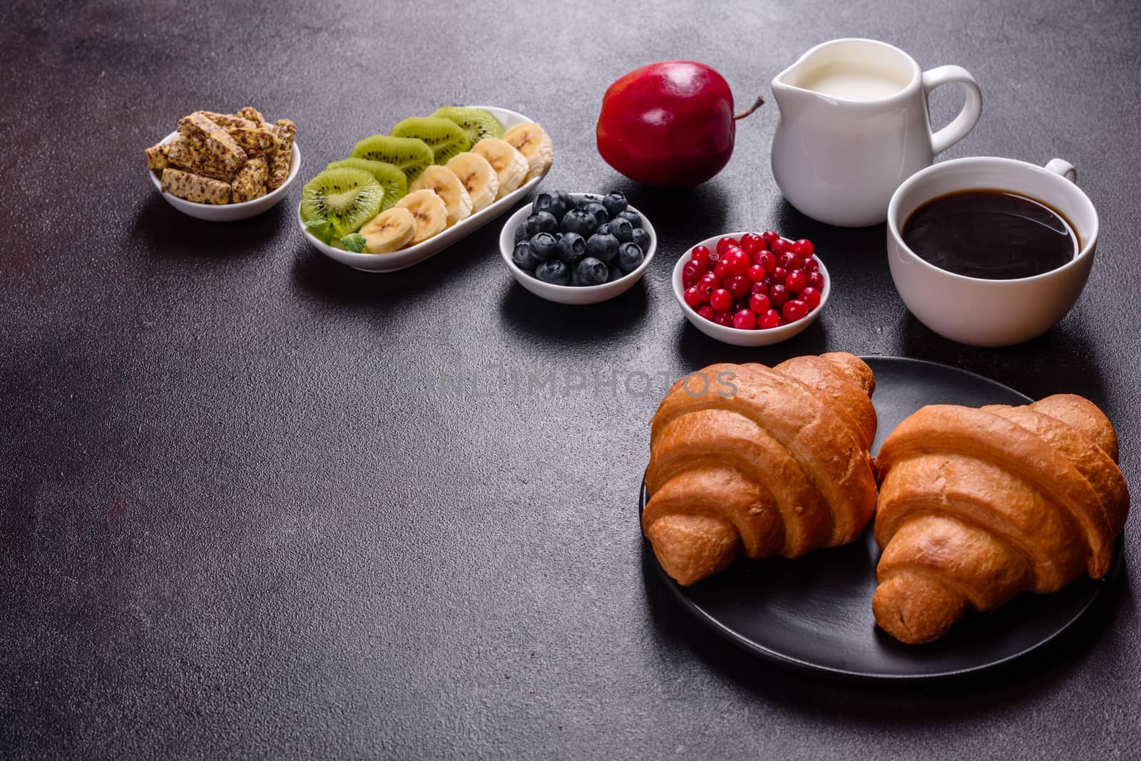 Delicious breakfast with fresh croissants and ripe berries on a beautiful wooden table