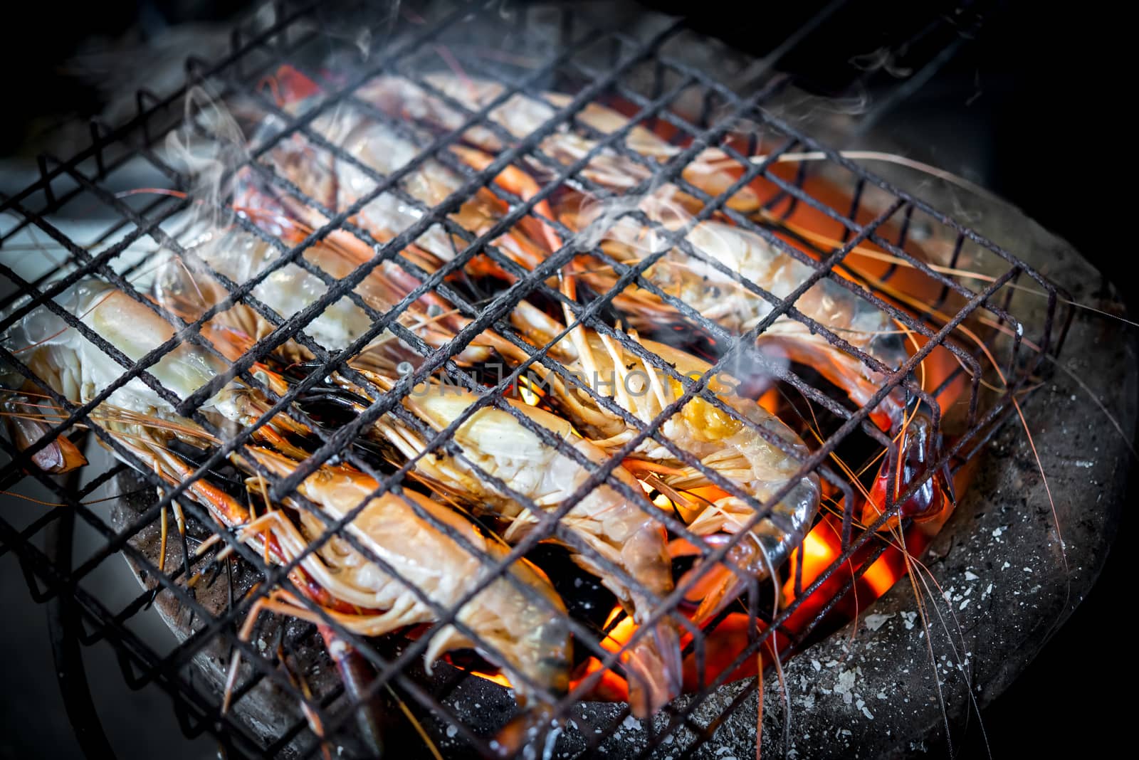 Grilled shrimp (Giant freshwater prawn) grilling with charcoal for sale at Thai street food market or restaurant in Bangkok Thailand