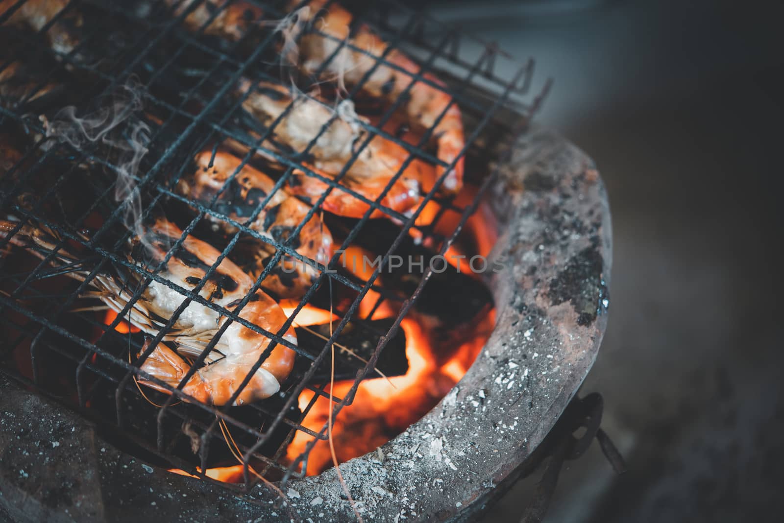 Grilled shrimp (Giant freshwater prawn) grilling with charcoal for sale at Thai street food market or restaurant in Bangkok Thailand