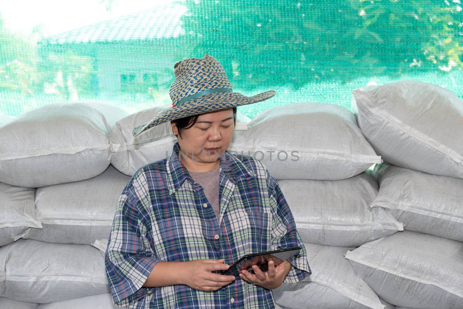Asian woman smart farmer agriculturist happy at a Fertilizer composting plant with Organic Fertilizer, Compost (Aerobic Microorganisms) from animal waste for use in the organic agriculture industry