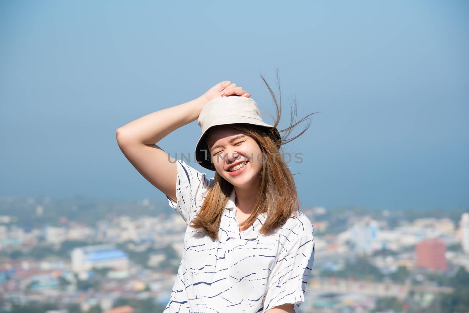 Asian pretty woman with hair blown relax at sea viewpoint with loneliness and lonely emotion in concept travel, vacation, leisure in life