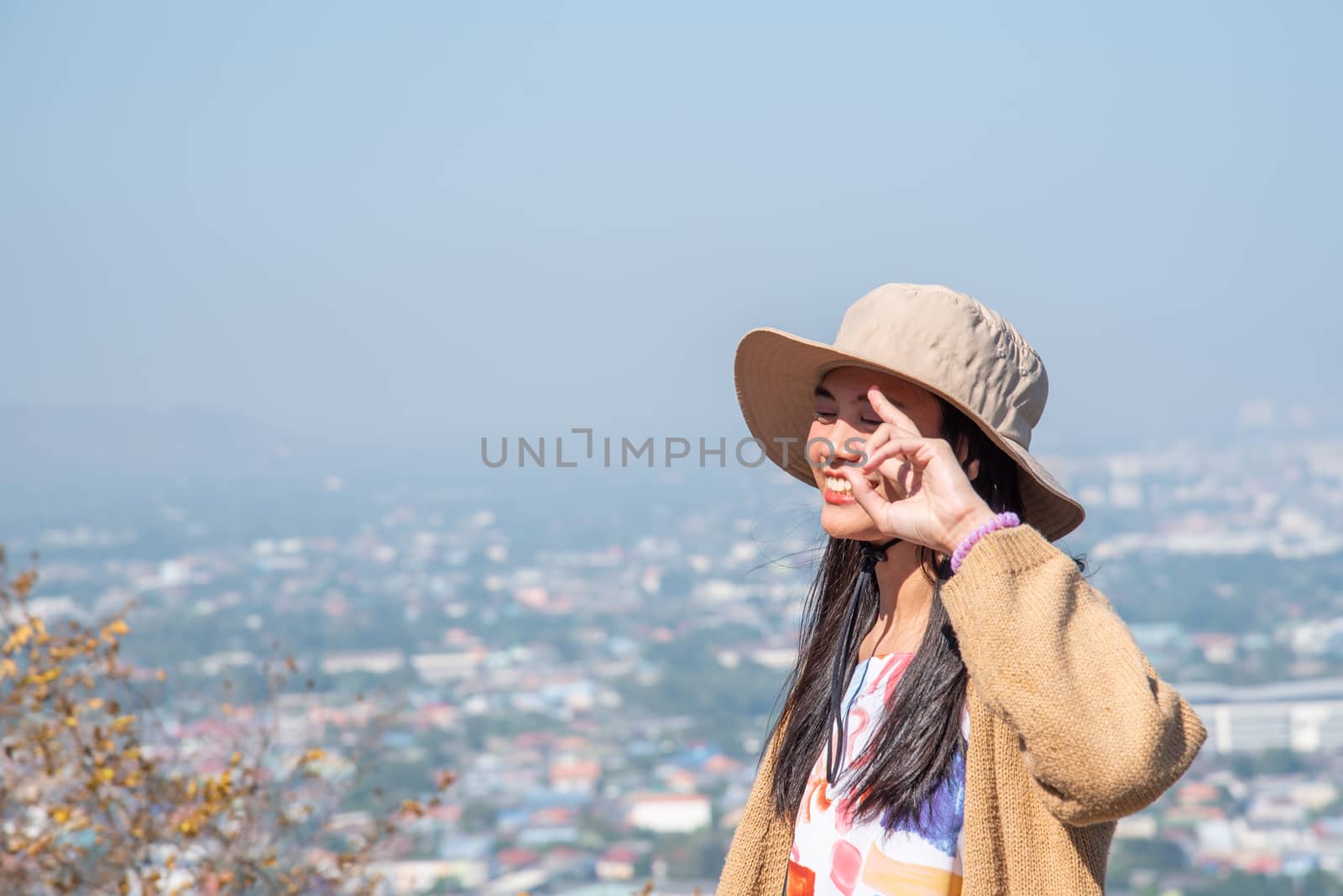 Asian pretty cute woman with hat relax at seaside city landscape viewpoint on mountain with happy and freedom emotion in concept travel, vacation, leisure in life