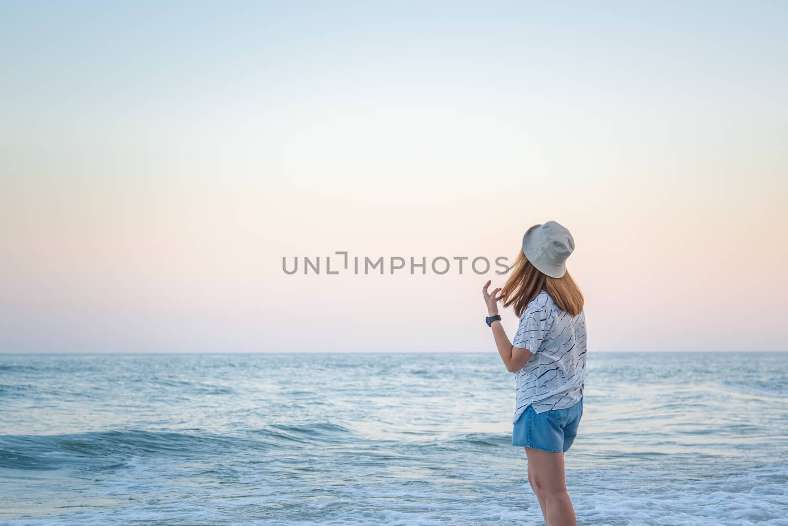 Asian pretty cute woman relax at sea beach with happy and freedom emotion in concept travel, vacation, leisure, fun in life