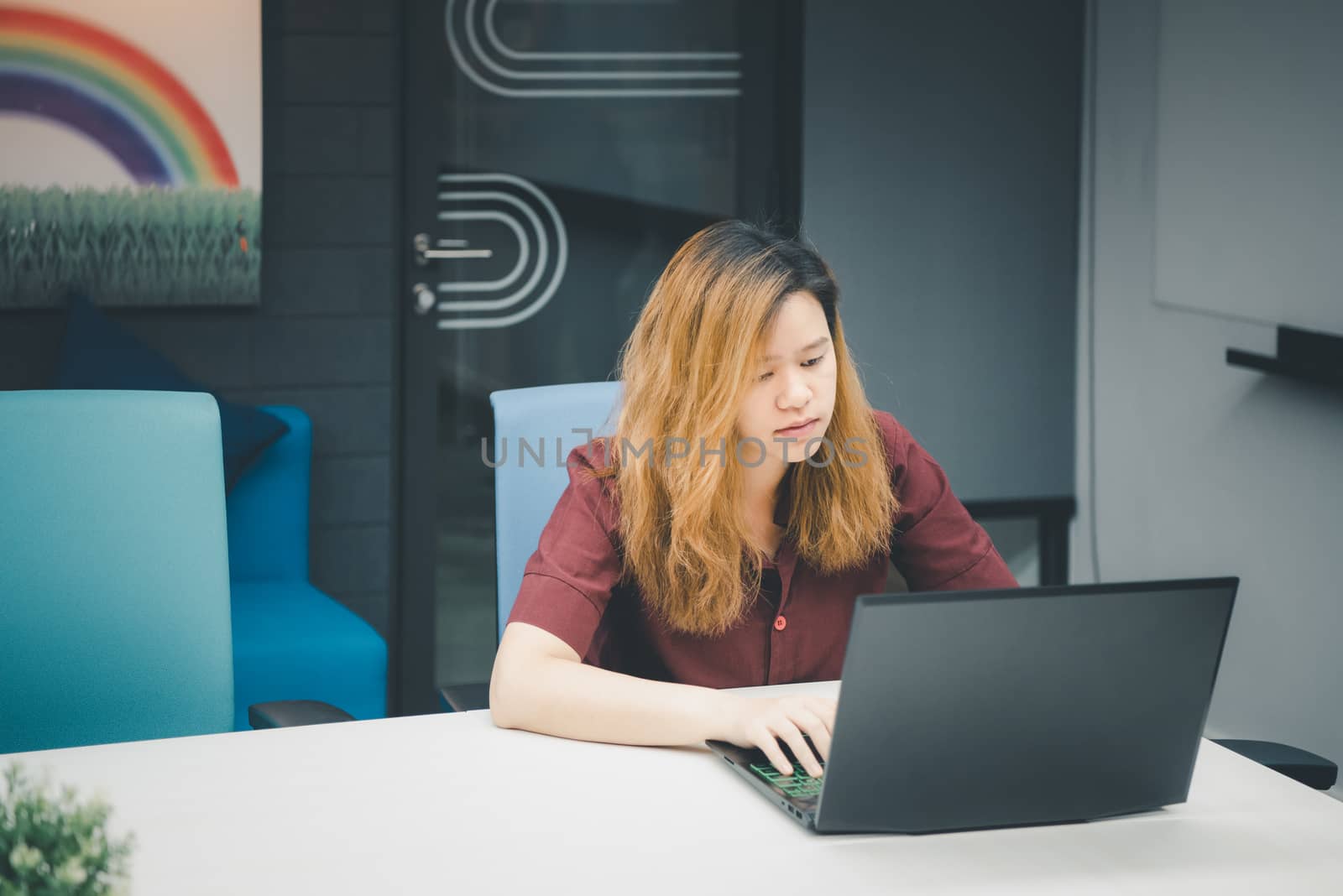 Woman working by laptop in office with thinking by PongMoji