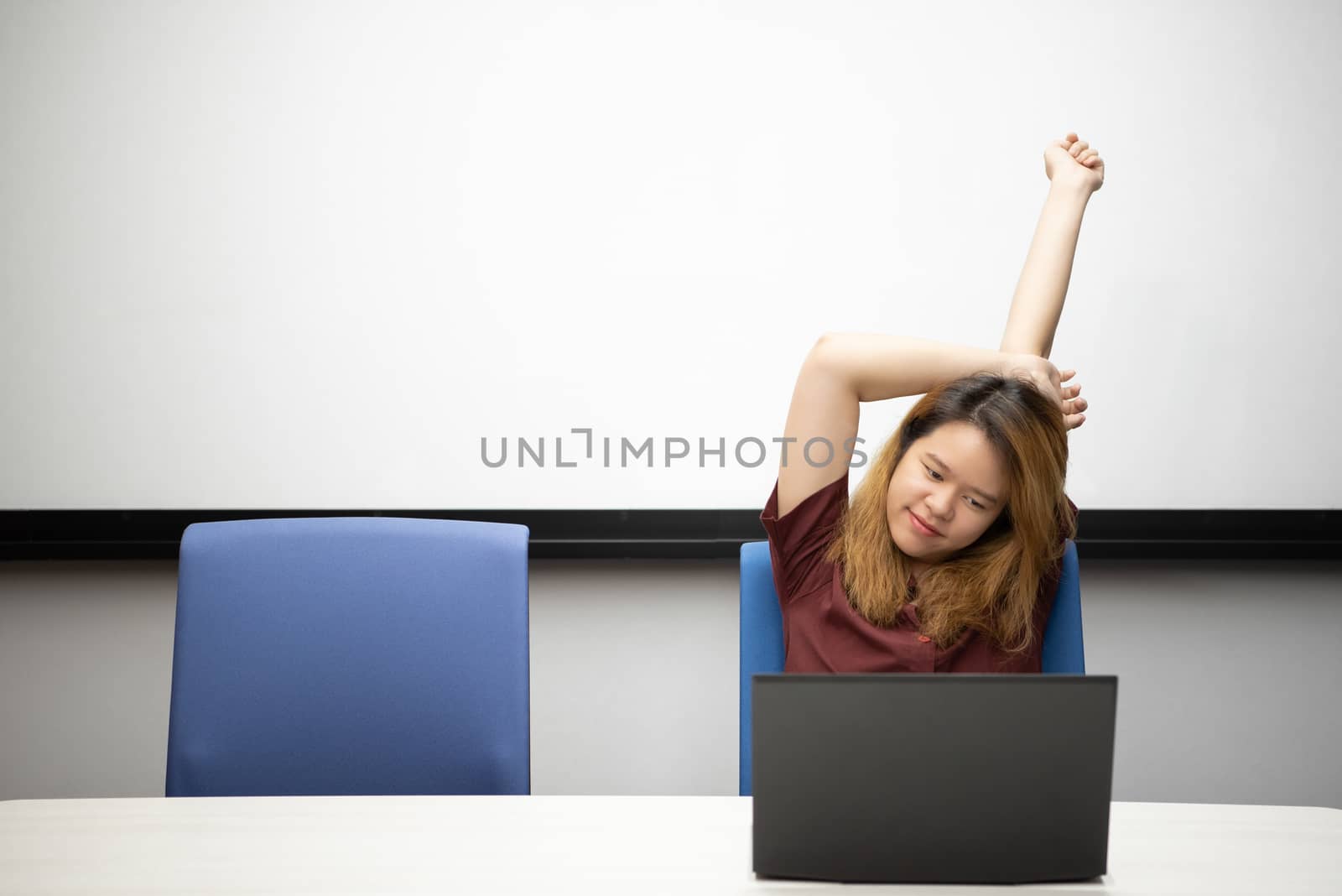 Asian woman is student,businesswoman working by computer notebook, laptop in office meeting room with whiteboard background with relax, concentrate emotion in concept working woman,success in life