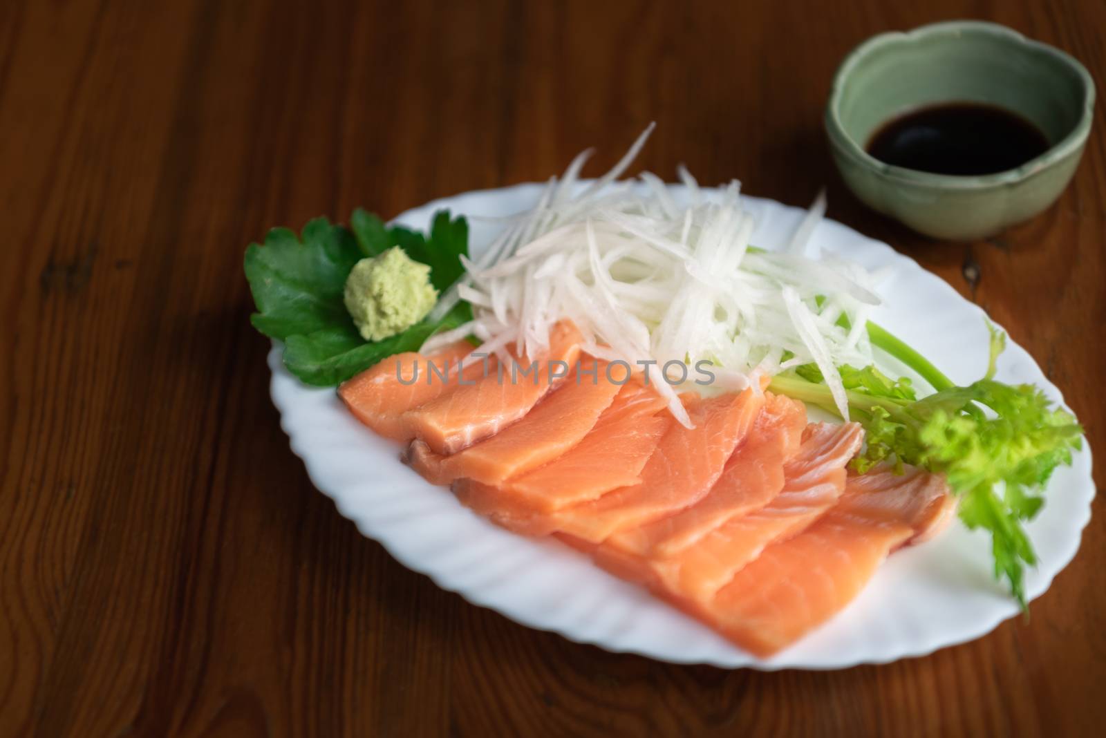 Japanese food delicacy consisting sashimi salmon of very fresh raw salmon fish sliced into thin pieces serving with radish sliced in japan restaurant