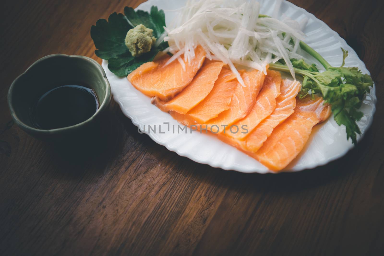 Japanese food delicacy consisting sashimi salmon of very fresh raw salmon fish sliced into thin pieces serving with radish sliced in japan restaurant