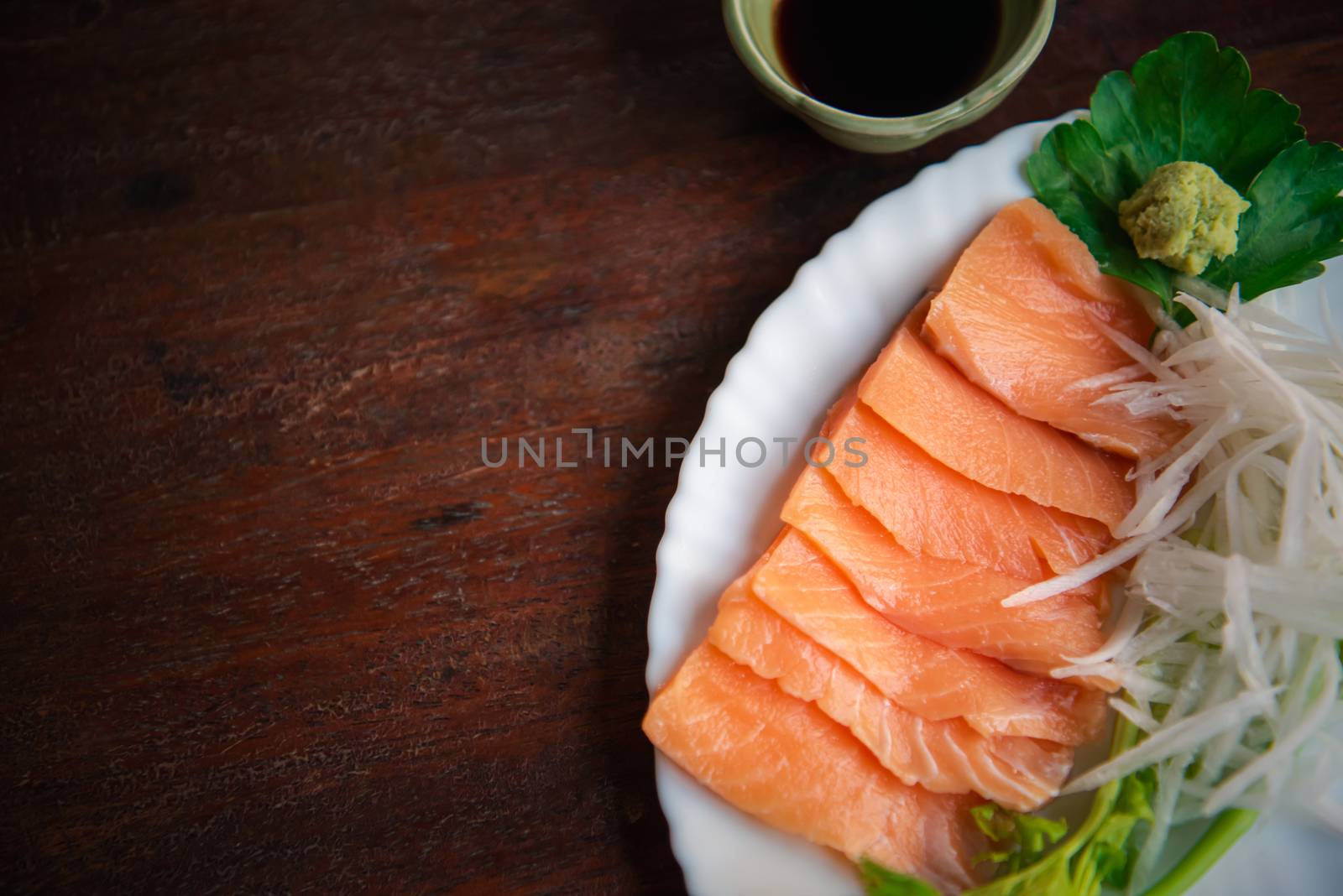 Japanese food delicacy consisting sashimi salmon of very fresh raw salmon fish sliced into thin pieces serving with radish sliced in japan restaurant