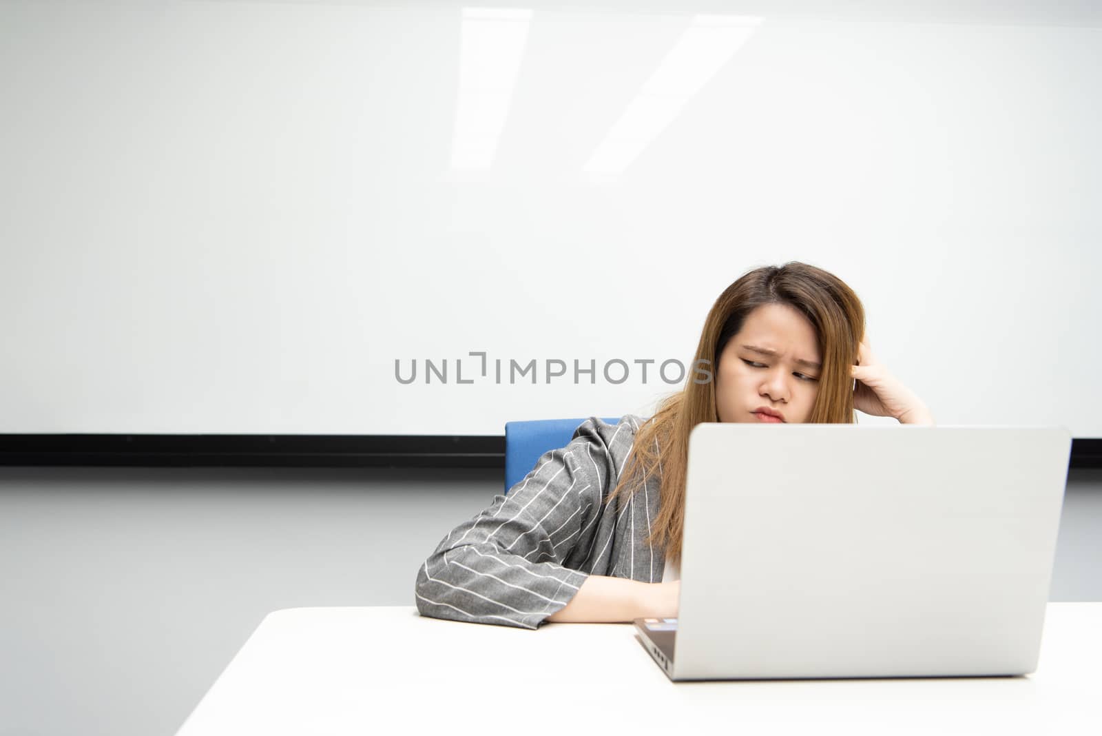 Asian woman is student,businesswoman working by computer notebook, laptop in office meeting room with whiteboard background with thinking, concentrate emotion in concept working woman,success in life