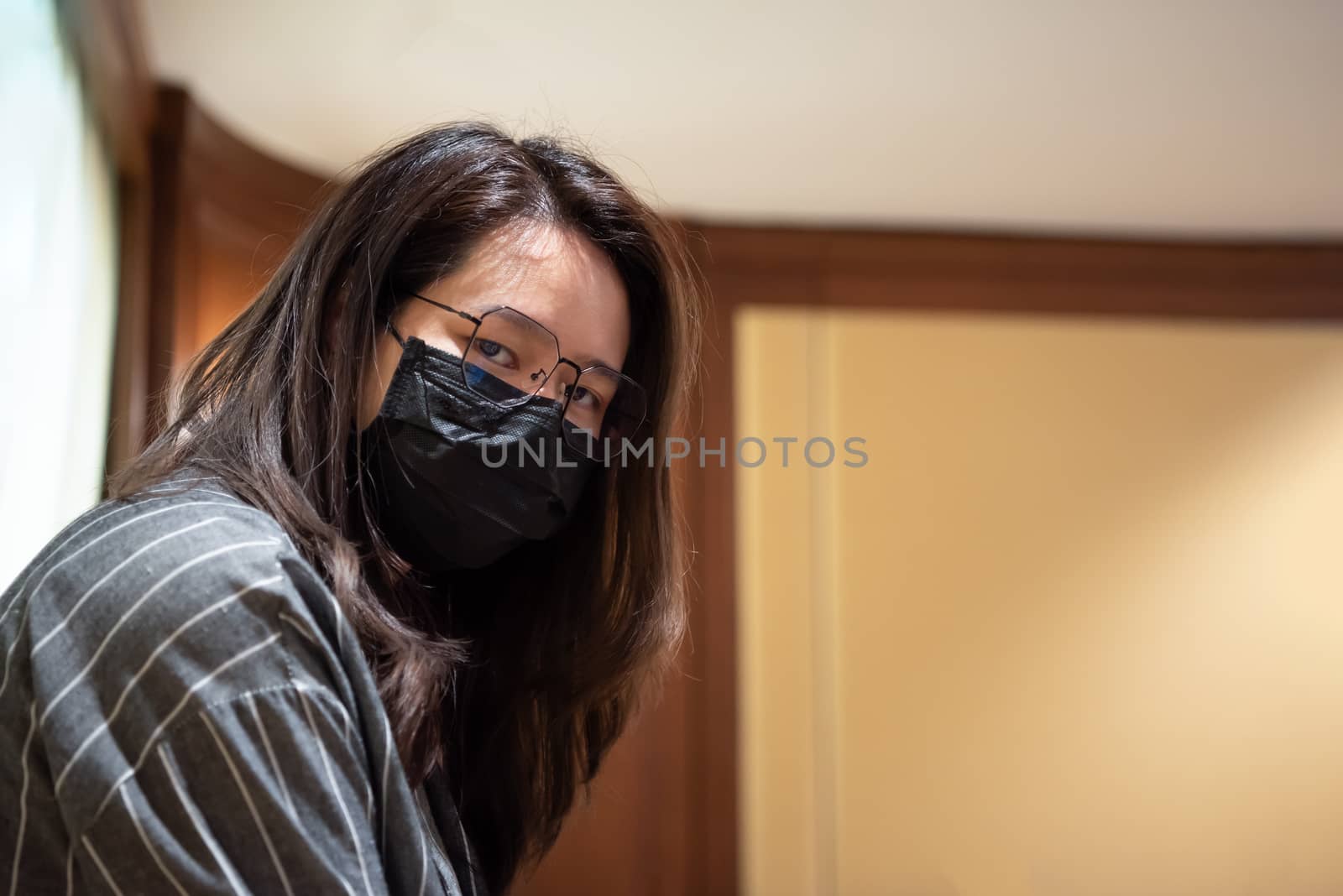 Asian pretty woman wearing mask respiratory protection mask against epidemic flu covid19 or corona virus from wuhan in office with fear emotion in concept illness, outbreak, healthcare in life