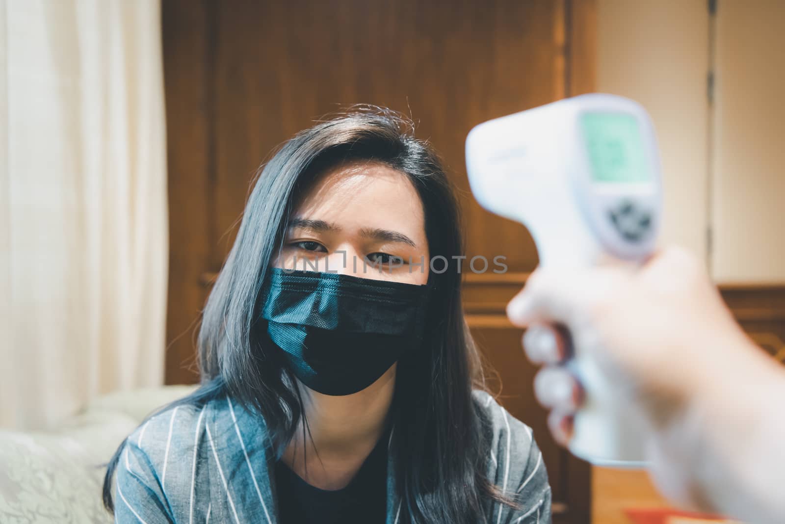 Woman wearing mask protection flu with thermoscan by PongMoji