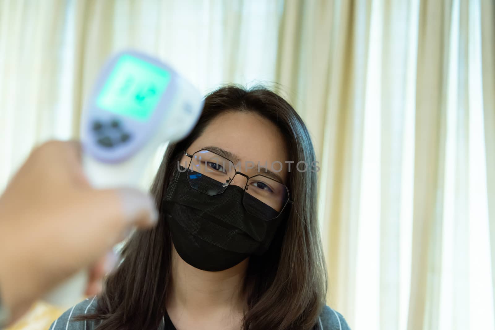 Woman wearing mask protection flu with thermoscan by PongMoji