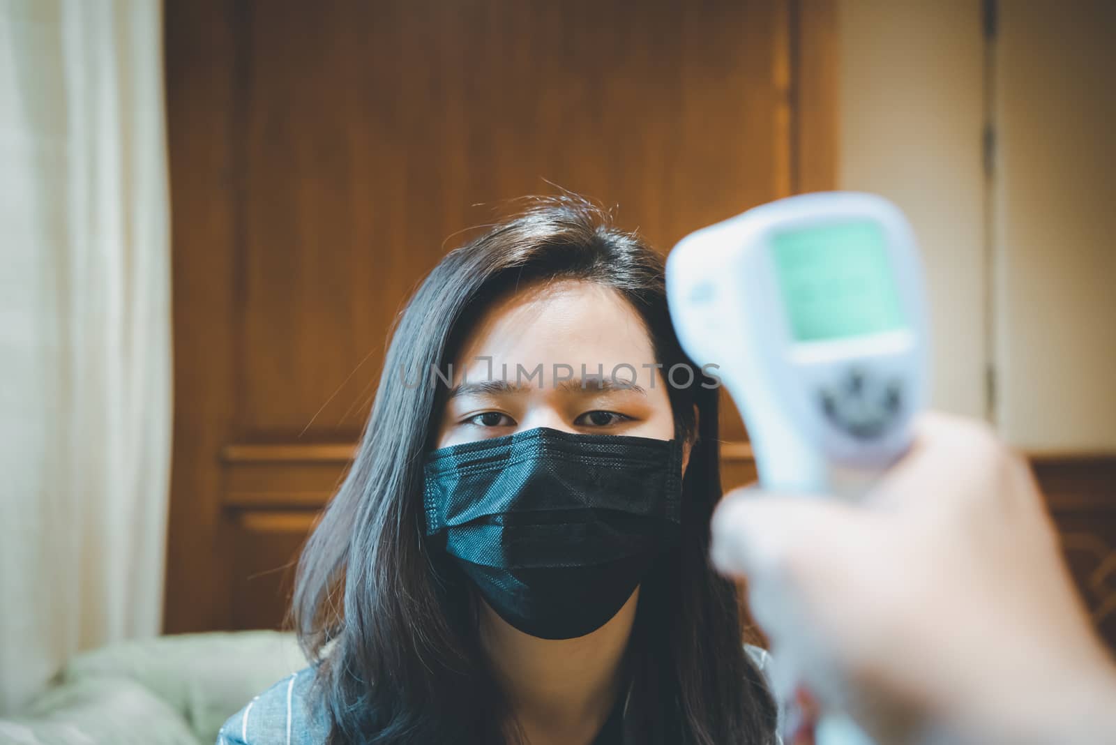 Woman wearing mask protection flu with thermoscan by PongMoji